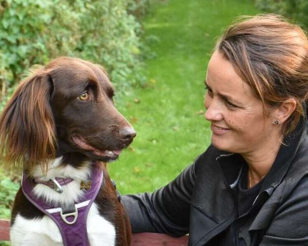 Karina Fisker på en bænk med hunde