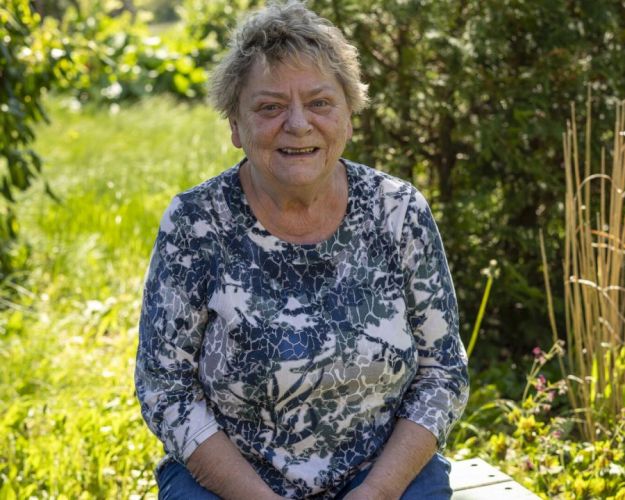 Kirsten på en bænk i haven