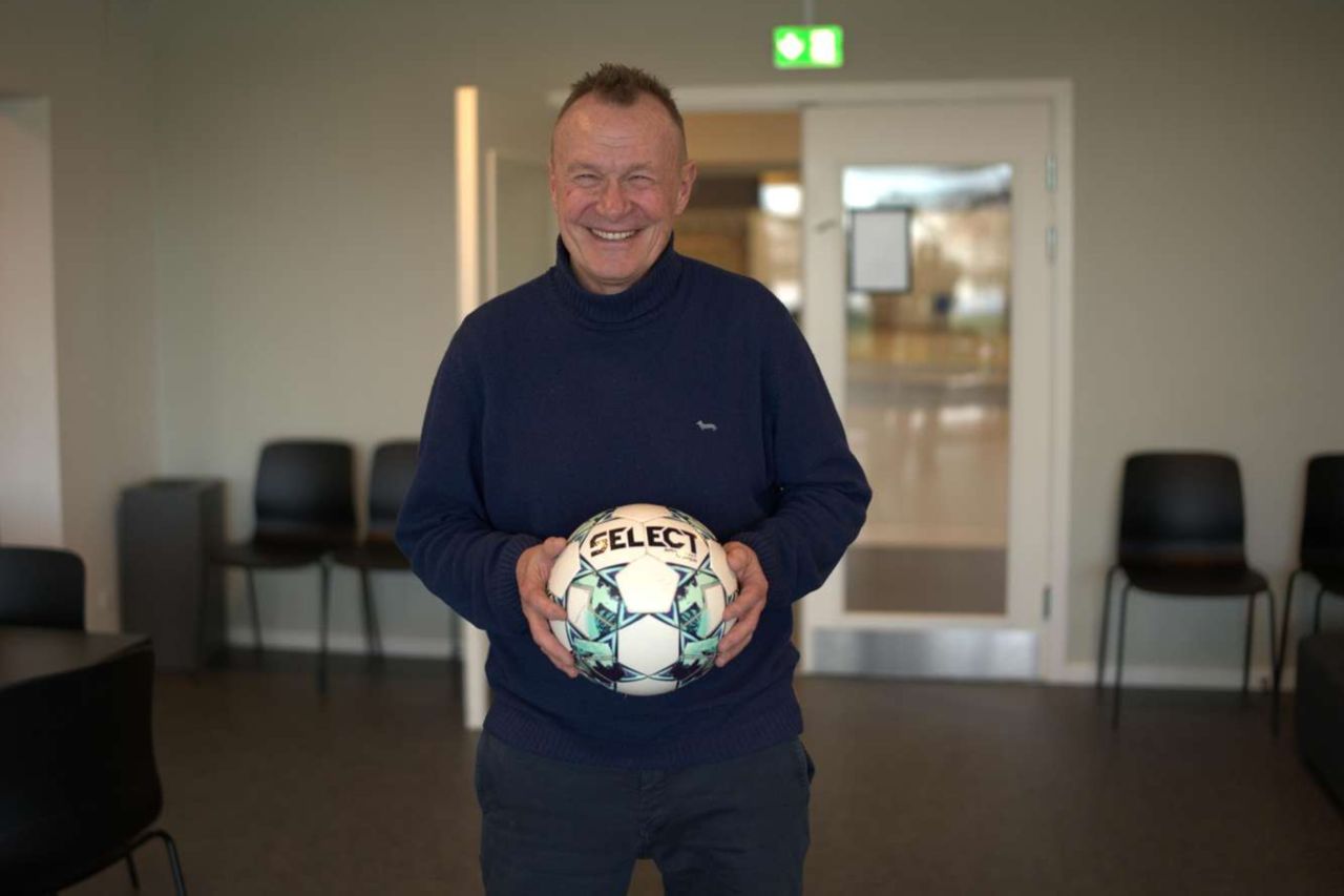 Per Frimann griner med en fodbold i hænderne